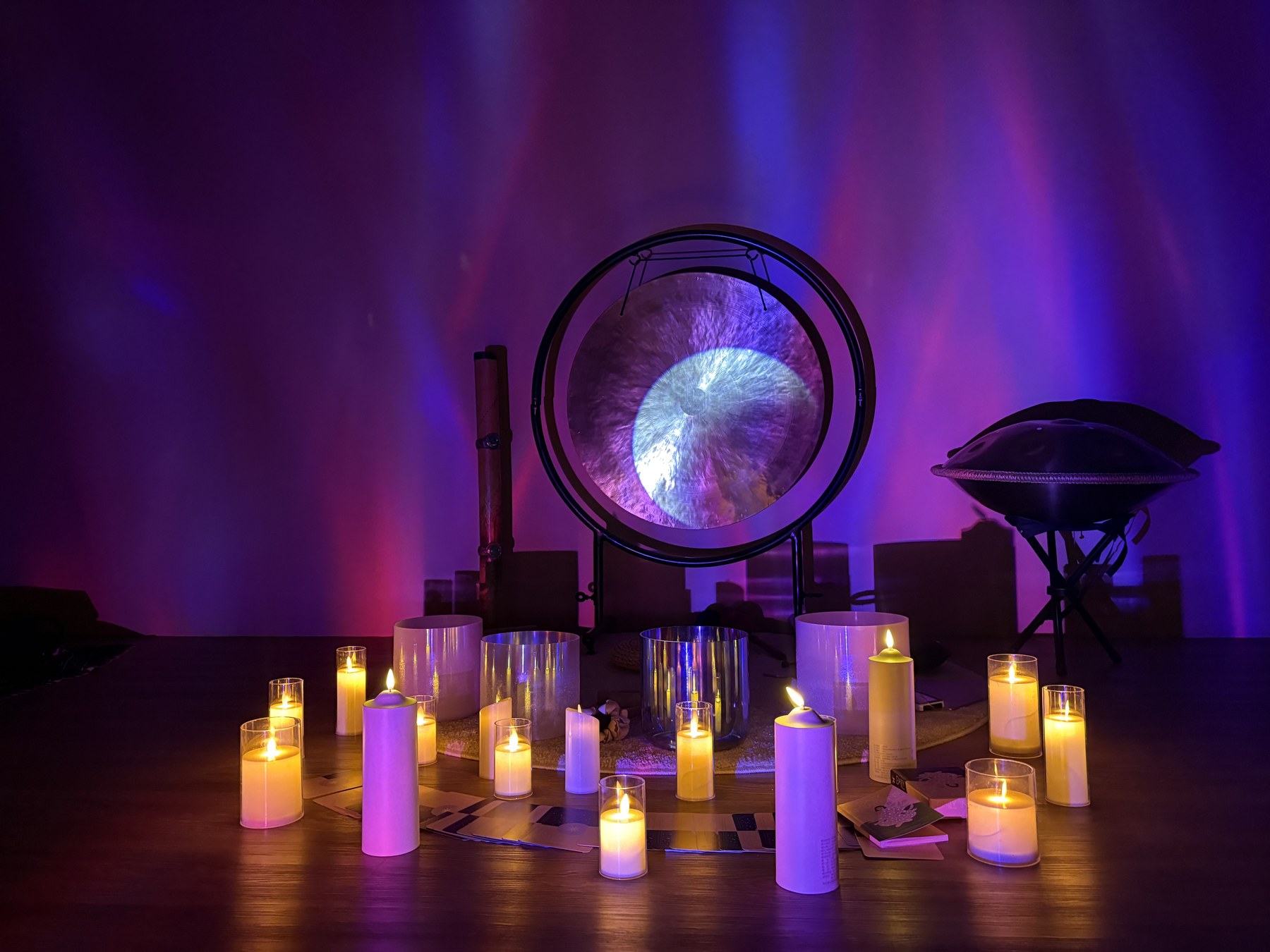 Gong and sound healing bowls under soft colored light